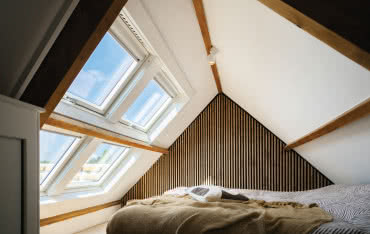 Słoneczna sypialnia na poddaszu z oknami dachowymi FAKRO